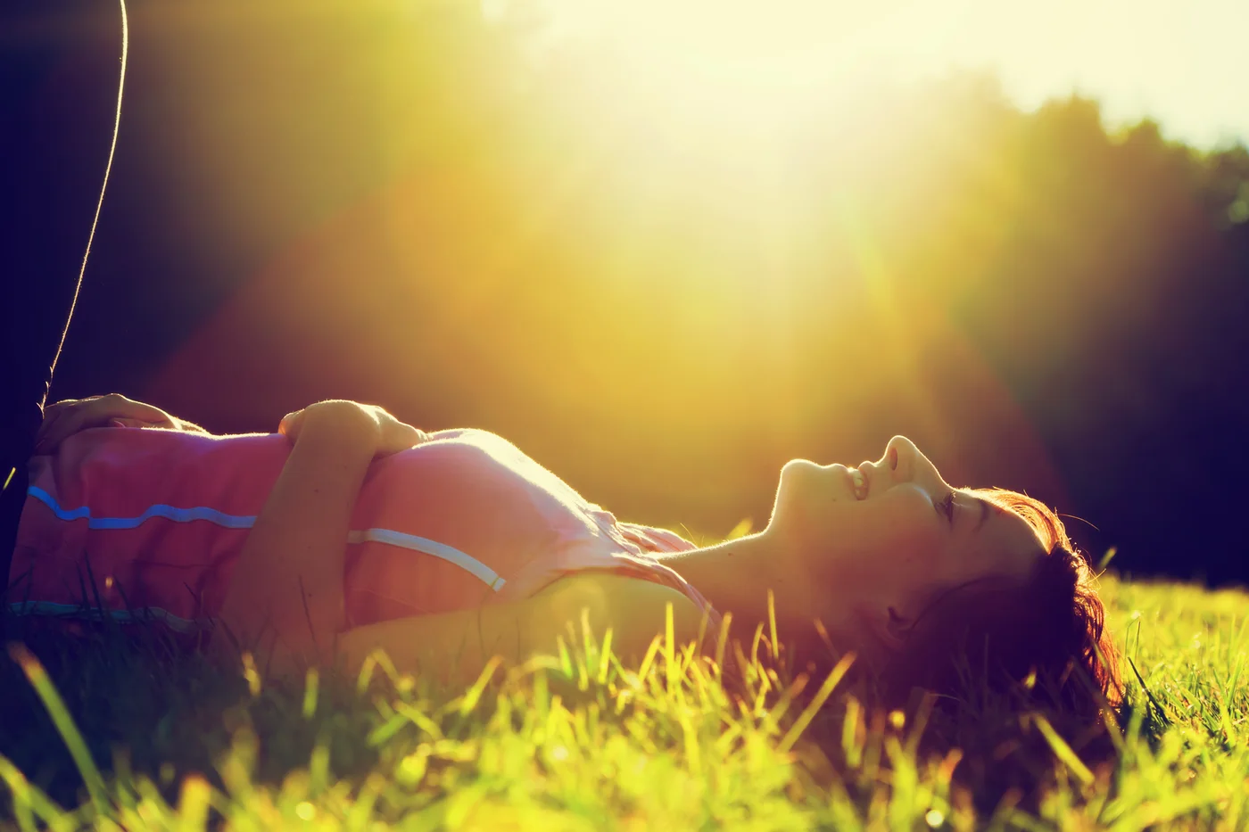 Woman relaxing in the grass in the sun after a day outdoors