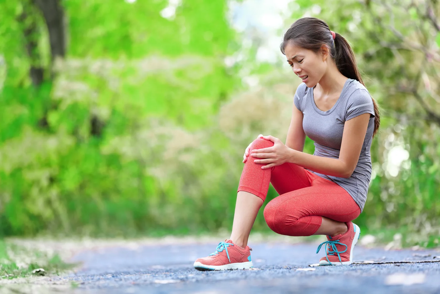 Active woman pausing to hold her knee after a run, representing everyday joint discomfort